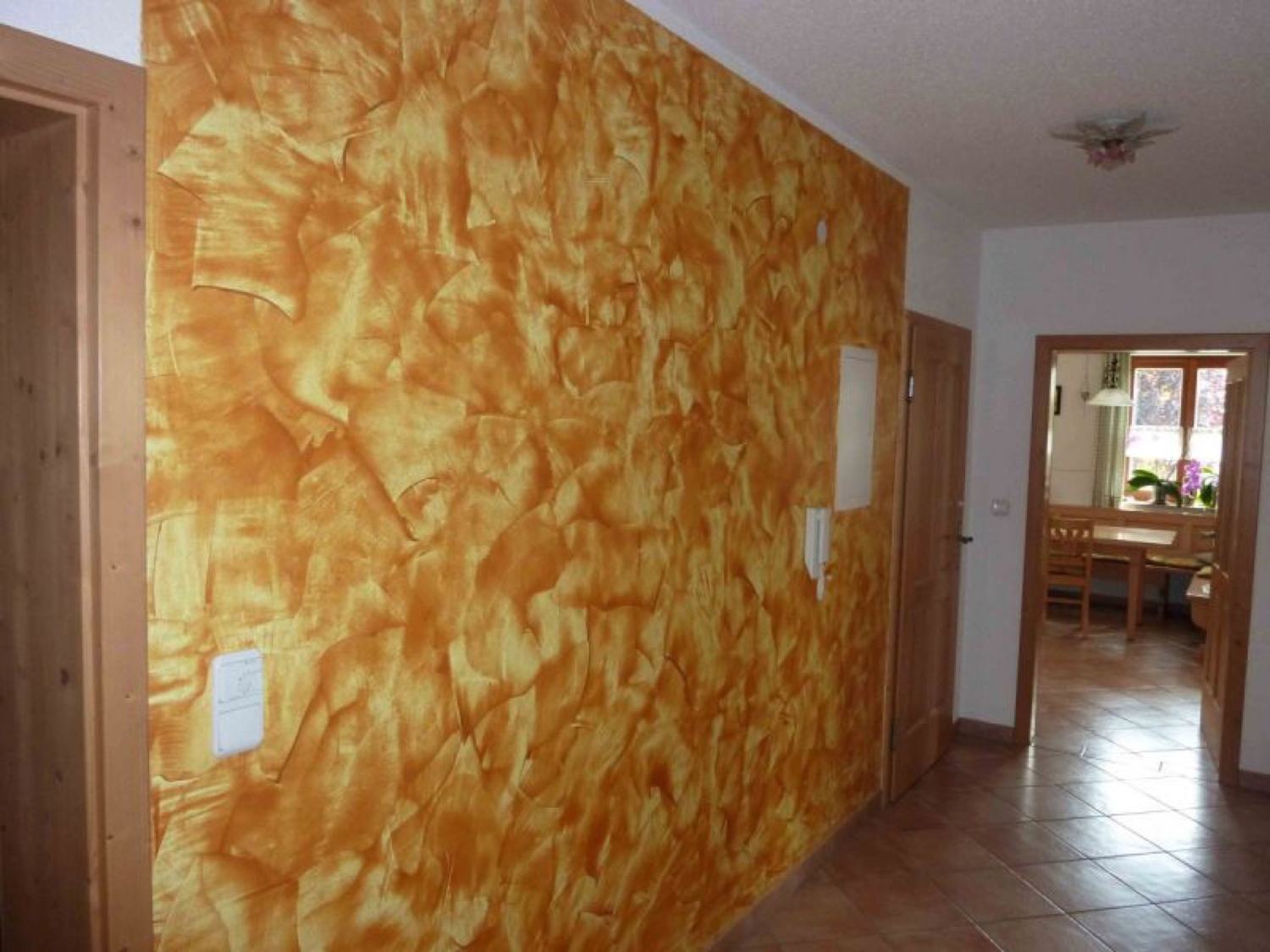Dekorative Lasurtechnik in Orange auf einer Innenwand